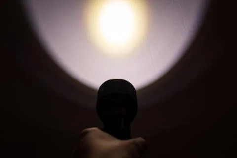 A hand holding a flashlight in the dark Stock Photos
