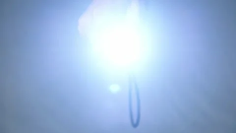 Hand Holding Flashlight Turns on Bright Beam Towards Camera Top View Stock Footage 315795843