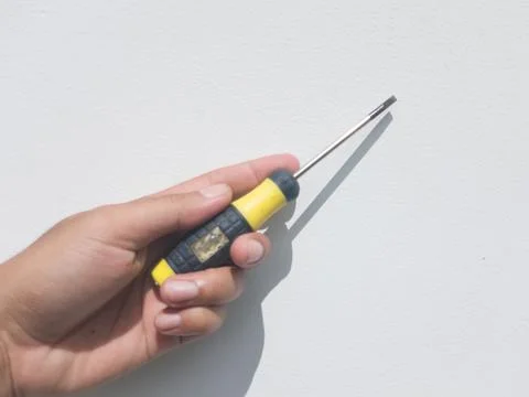 Hand holding flathead screwdriver tool Stock Photos