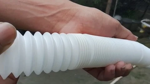 Hand holding flexible white plastic pipe with corrugated texture. 스톡 동영상 346617783