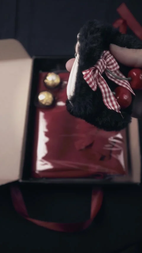 Hand Holding Fluffy Cherry Accessory Over Luxury Red Gift Box Unboxing Stock Footage 322606556