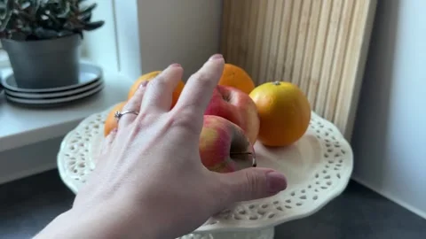 Hand holding fresh apple over plate Stock-Footage 335589481