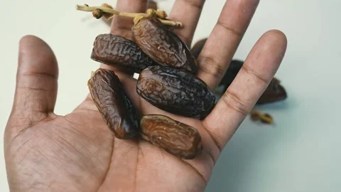Hand Holding Fresh Dates, A hand holding several dates, showcasing their ri.. Stock Footage 304974730