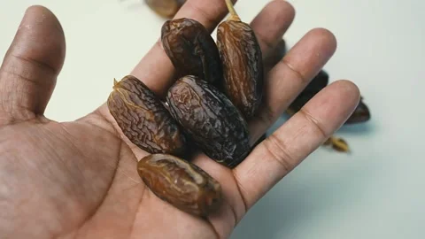 Hand Holding Fresh Dates, A hand holding several dates, showcasing their ri.. 動画素材 304974745