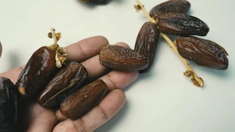 Hand Holding Fresh Dates, A hand holding several dates, with more dates att.. Stock Footage 304974778