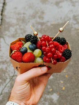 Hand Holding Fresh Mixed Berry Basket at Ljubljana Market Stockfoto's