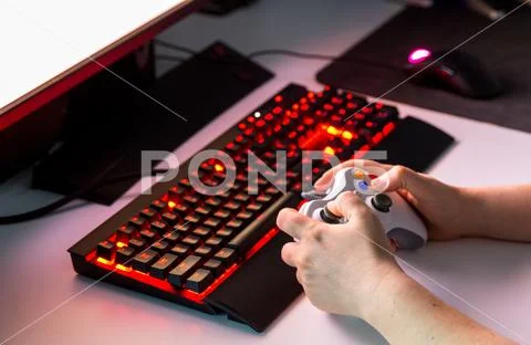 Hand holding game console controller playing game on the display Stock Photos
