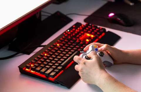 Hand holding game console controller playing game on the display Stock Photos