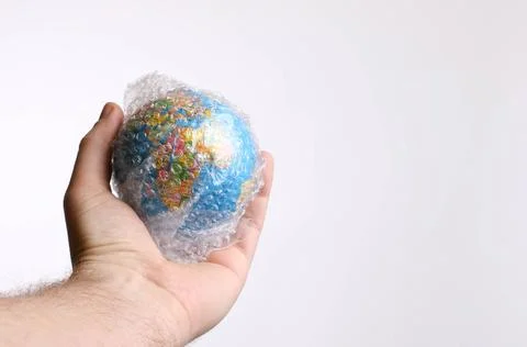 Hand holding globe packed in bubble wrap Stock Photos