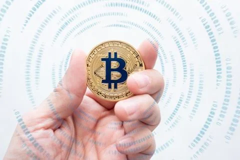 Hand holding gold bitcoin on with binary number effect on white backgorund.di Foto stock