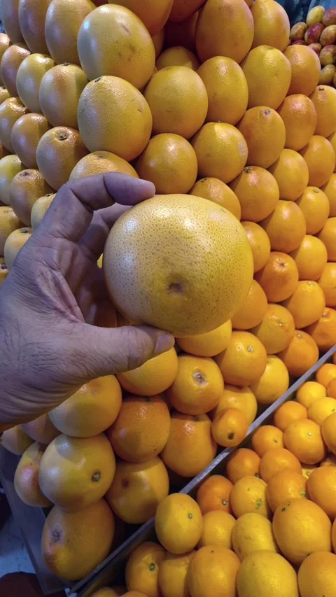 A hand holding grapefruit while shopping in a supermarket Stock Footage 341553794