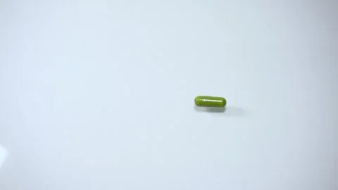 Hand holding green capsule pill close up isolated on white background Vídeos de archivo 342838815
