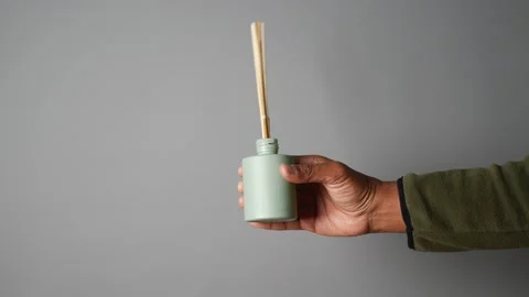 Hand holding a green diffuser with bamboo sticks Stock Footage 300950363
