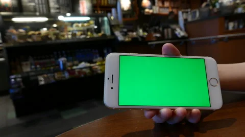 Hand holding green screen iphone inside Starbucks store Stock-Footage 65437068