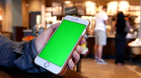 Hand holding green screen iphone inside Starbucks store Stock Footage 67523390