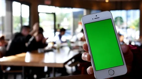 Hand holding green screen iphone inside Starbucks store Stock Footage 76600925