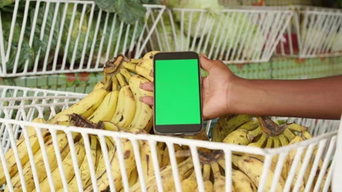 Hand Holding Green Screen Smartphone Over Ripe Bananas at Grocery Market Stock Footage 345839771