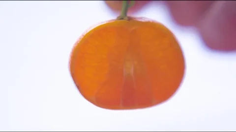 Hand holding a halved orange Stock Footage 76140166