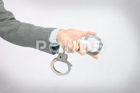 The hand holding the handcuffs. Stock Photos