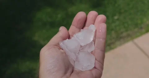 Hand holding ice cubes outside in summer Stock-Footage 310588584