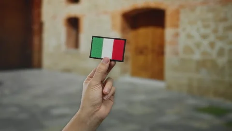 Hand holding italian flag patch indoors in historic university setting symb.. Stock Footage 311011740