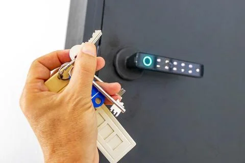 Hand holding keys from pin code box on hotel lobby wall Thailand. Foto stock