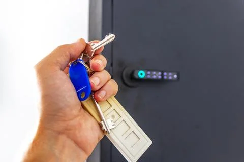 Hand holding keys from pin code box on hotel lobby wall Thailand. Stock-Fotos