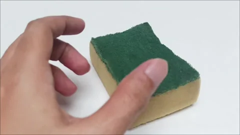 Hand holding kitchen dishwashing sponge on white background Stock Footage 340118260
