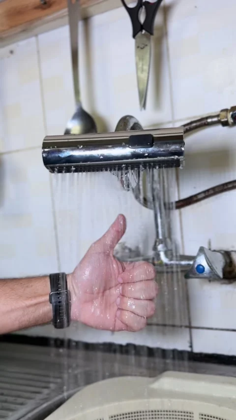 Hand Holding Kitchen Faucet Spraying Water Stock Footage 345219070