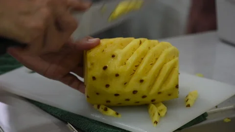 Hand holding knife slicing pineapple Stock Footage 233270439