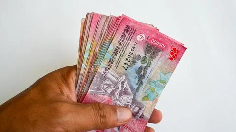Hand Holding a Large Stack of Indonesian Rupiah 100000 Banknotes Stock Photos