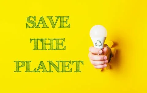 Hand Holding LED Bulb with Save the Planet Message on Yellow Background Stock Photos