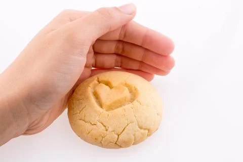 Hand holding a Light brown cookie with a pattern on a white background Foto stock
