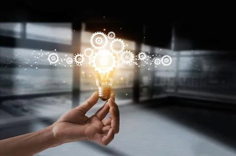 Hand holding light bulb and cog inside. Idea and imagination. Creative and .. Stock Photos