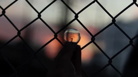 Hand holding light bulb during sunset . Stock Footage 165433944