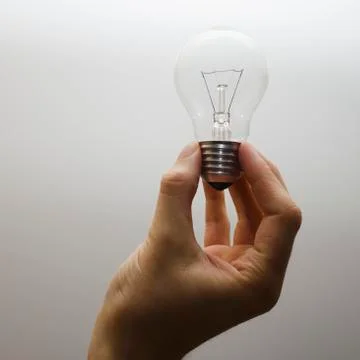 Hand holding light bulb Stock Photos
