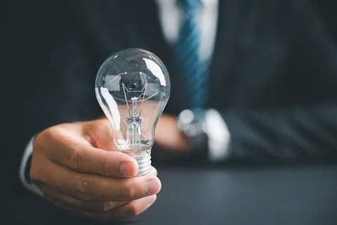 A hand holding a light bulb, symbolizing ideas and innovation. Perfect for .. Stock Photos