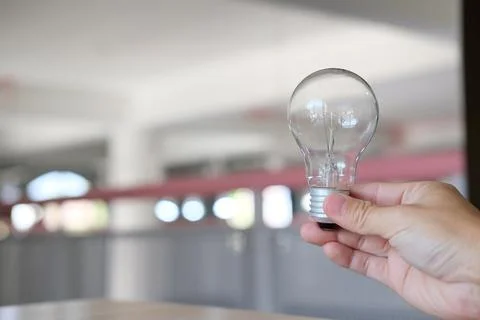 Hand holding a light bulb on a table notion of idea Foto stock