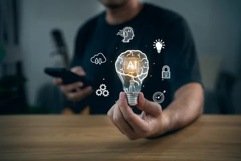 Hand holding light bulb with virtual AI brain inside and glowing technology.. Stock Photos
