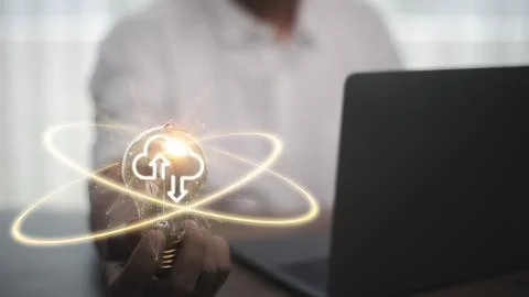 Hand holding lightbulb with cloud computing and technology icons such as la.. Fotos Stock