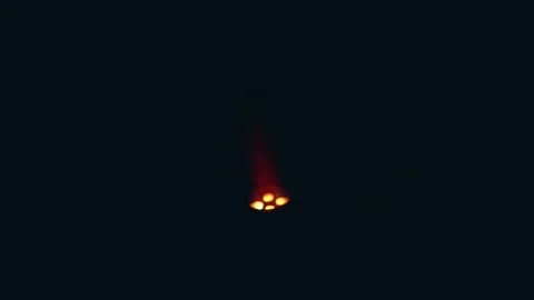 A hand holding a lighter, igniting a flame against a dark background Stock-Footage 305996187