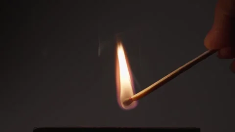 Hand Holding Lit Match with Tall Flame Against Dark Background Video stock 337412005