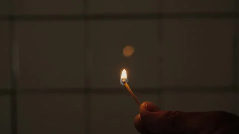 Hand holding lit matchstick in low key scene Stock Footage 342866194