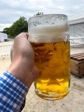 Hand holding a liter stein of refreshing beer Stock Photos