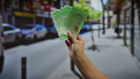 Hand holding malaysian ringgit banknotes in an urban street setting outside.. Stock Footage 310048009
