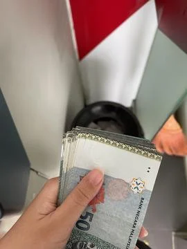 Hand Holding Malaysian Ringgit RM50 Bills After ATM Withdrawal Stock Photos