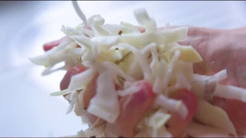 Hand holding marinated cabbage in the kitchen Vídeos de archivo 76140016