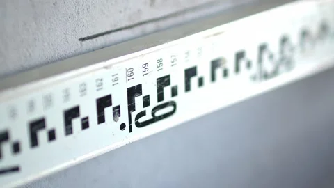 Hand Holding Marker Above Height Measurement Scale on Wall Stockbeeldmateriaal 336524917
