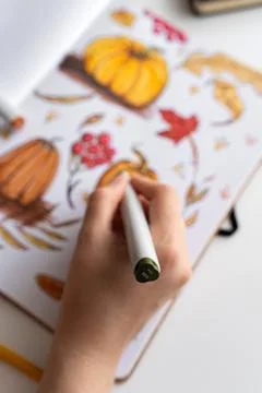 Hand holding marker while drawing autumn illustration Stock Photos