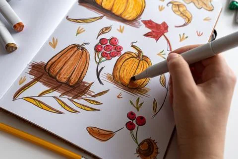 Hand holding marker while drawing autumn illustration Stock Photos